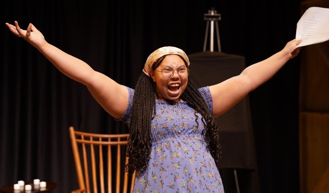 Alora performing on stage with arms raised
